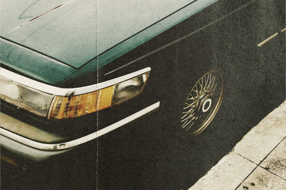 Close up detail of vintage car headlight with gold wheel rim visible
