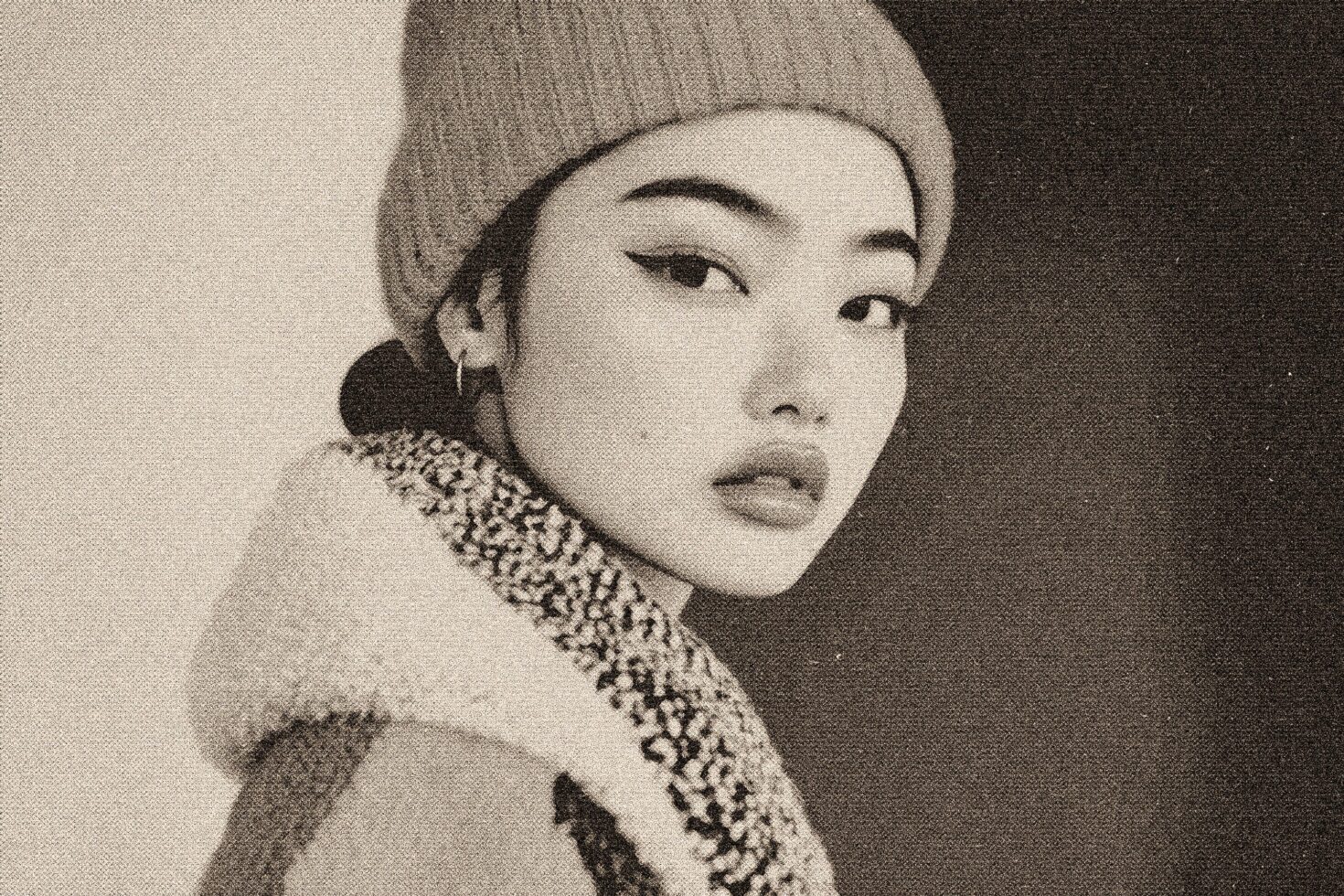 Grainy vintage portrait, woman in beanie with textured sweater, side profile
