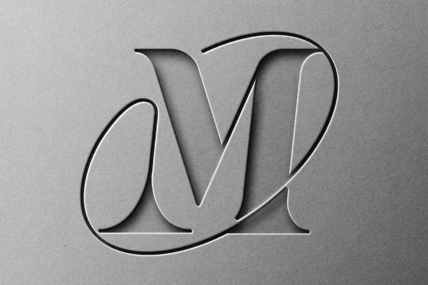 Embossed flowing script monogram letterform carved into neutral surface
