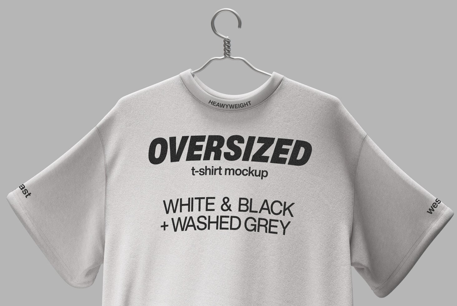Oversized cream tee with black text on metal hanger against gray backdrop