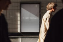 Blank grey screen mockup on subway wall with people walking by