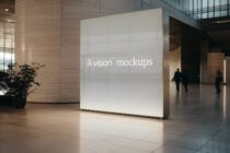Luminous white lightbox display in modern lobby with concrete columns