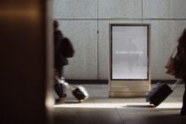 Blank screen on concrete subway kiosk at night