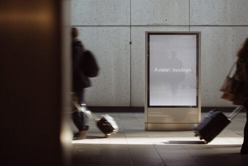 Blank screen on concrete subway kiosk at night