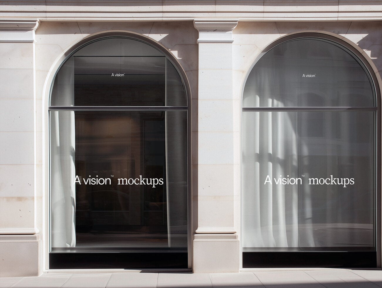 Two arched storefront windows with dark interior displays in minimal storefront