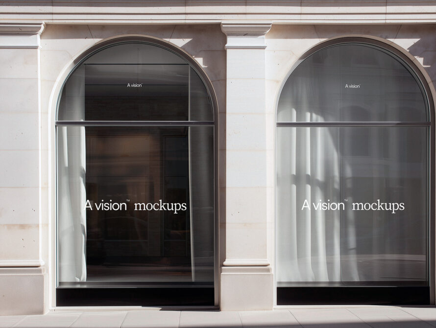 Two arched storefront windows with dark interior displays in minimal storefront