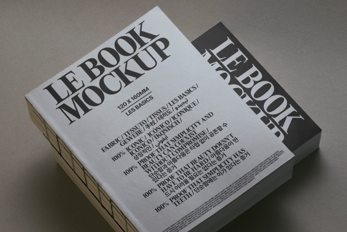 White book mockup with black spine angled view on neutral surface