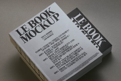 White book mockup with black spine angled view on neutral surface
