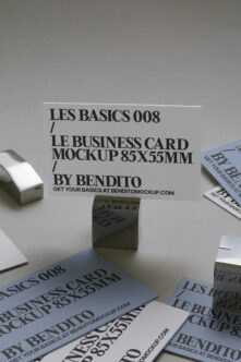Business card mockup 85x55mm on clear stand surrounded by stacked printed card samples