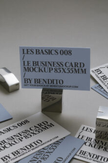 Business card mockup 85x55mm in blue displayed on stand with scattered printed samples
