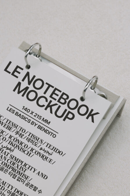 White hardcover notebook with silver spiral binding on cream fabric backdrop