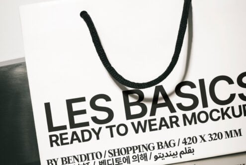 White shopping bag mockup with black rope handles tilted side angle view