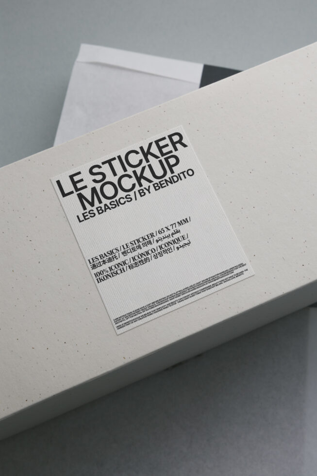 White sticker mockup on cream textured surface showing multilingual branding text