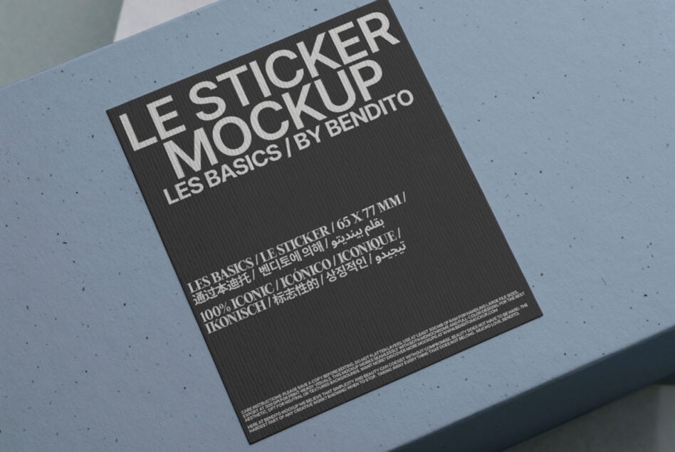 Dark sticker mockup angled on light blue background with minimalist design