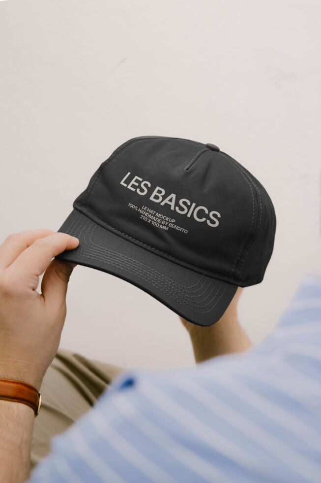 Black cap mockup held in hands with embroidered branding visible