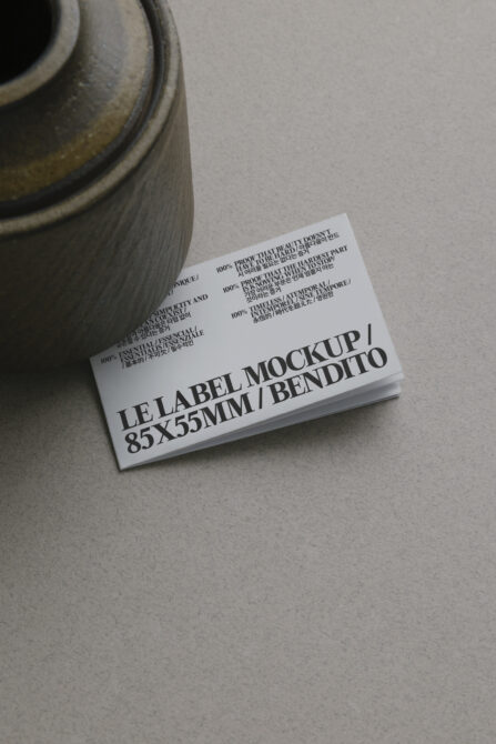 White business card stack beside textured pottery vessel on desk