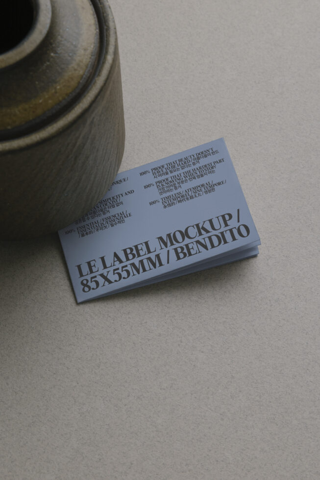 Blue business card stack next to ceramic pot on gray surface