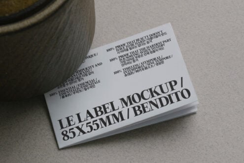 White business card mockup leaning by pottery jar showing label design
