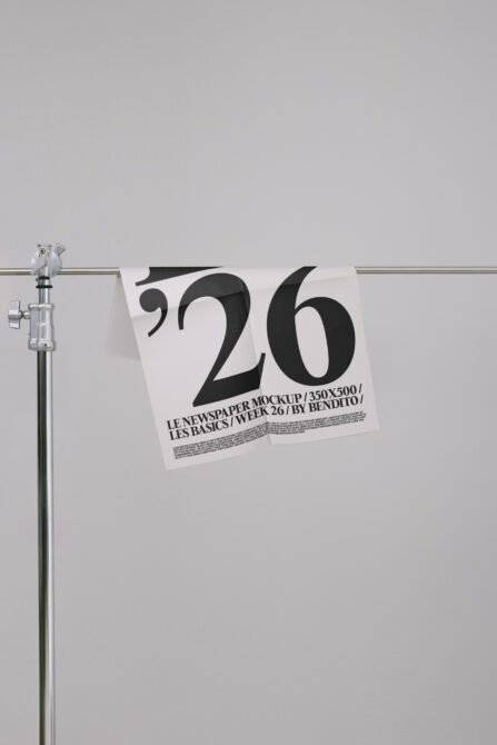 Newspaper mockup hanging on rod showing large '26' typography in black