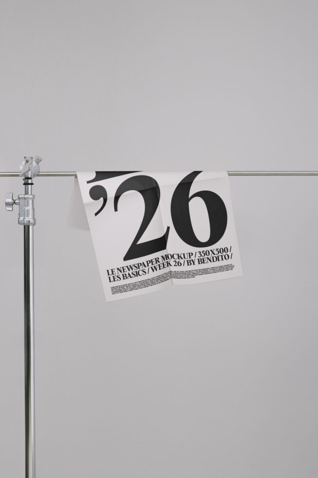 Newspaper mockup hanging on rod showing large '26' typography in black