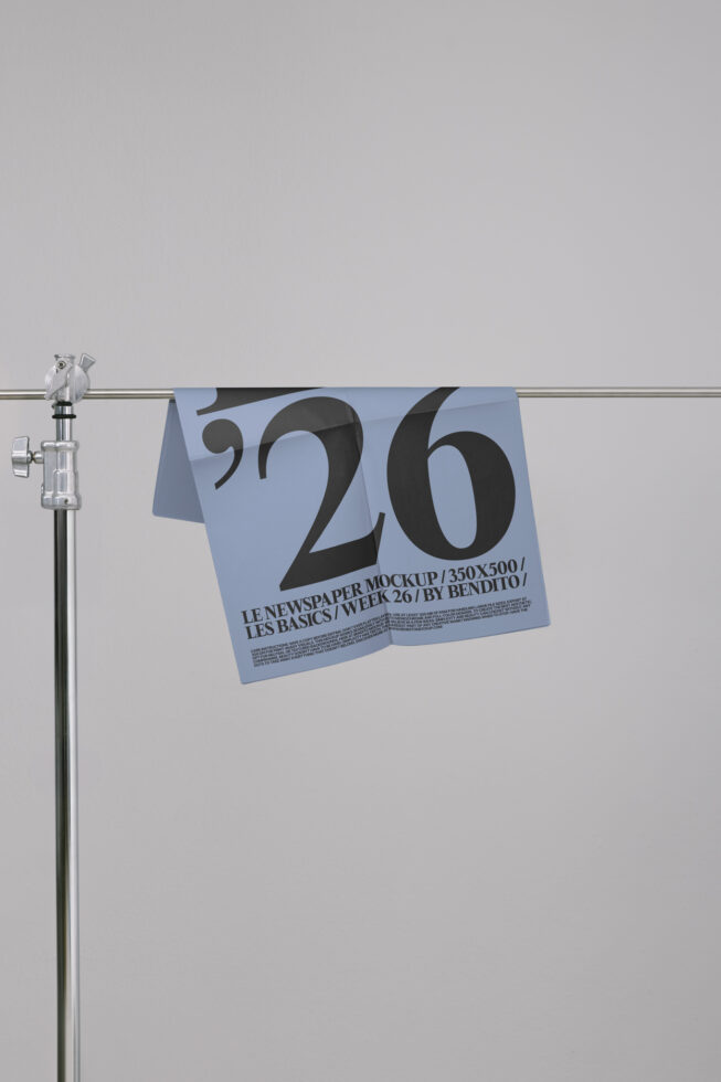 Newspaper mockup in blue hanging from metal rod with typographic design