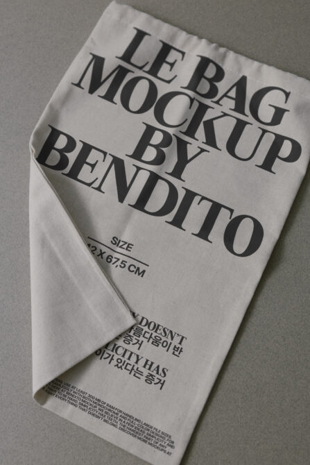 Natural canvas tote bag mockup with serif text printed on front, flat lay view
