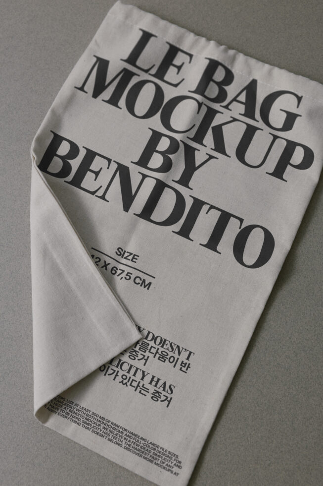 Natural canvas tote bag mockup with serif text printed on front, flat lay view