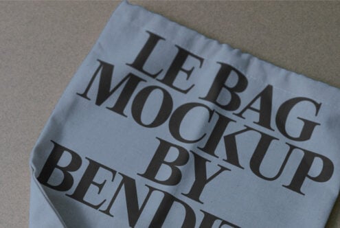 Light blue fabric bag mockup with serif text visible, tilted perspective shot
