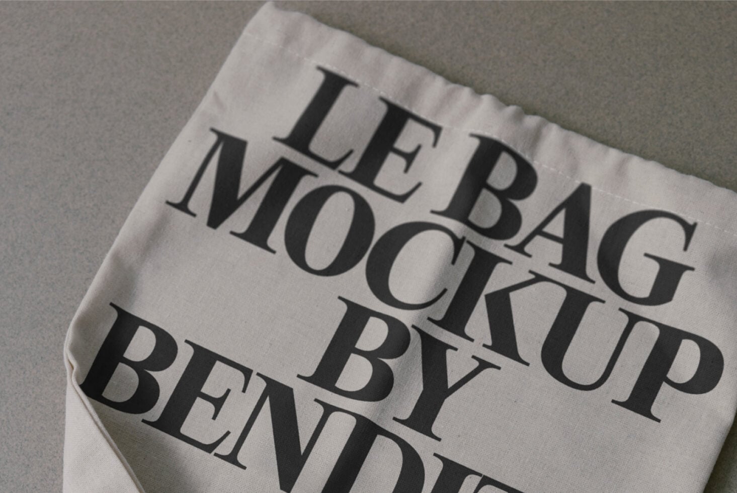 Cream colored fabric bag mockup with serif text printed on surface, tilted angle view