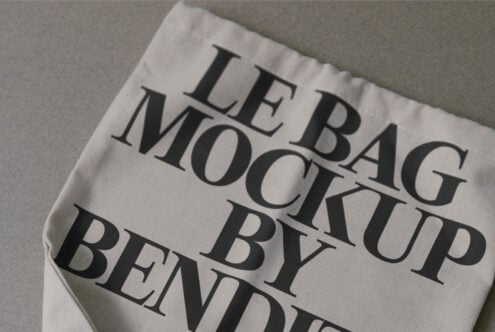 Cream colored fabric bag mockup with serif text printed on surface, tilted angle view