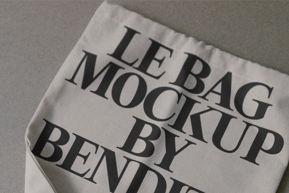 Cream colored fabric bag mockup with serif text printed on surface, tilted angle view