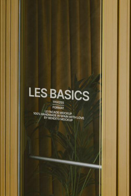 Storefront window with Les Basics text, plant shadow, gold frame on olive curtain backdrop