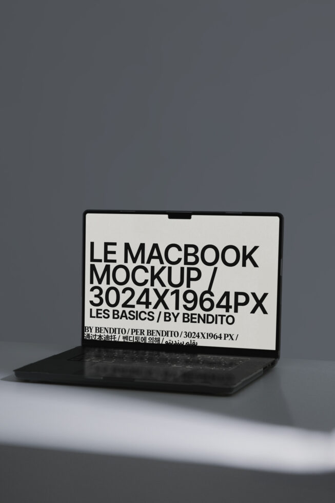 MacBook mockup with cream screen displaying black typography in side angle view