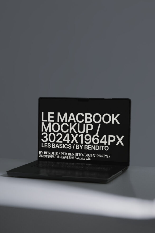 Black MacBook laptop mockup with white text on screen against gray backdrop