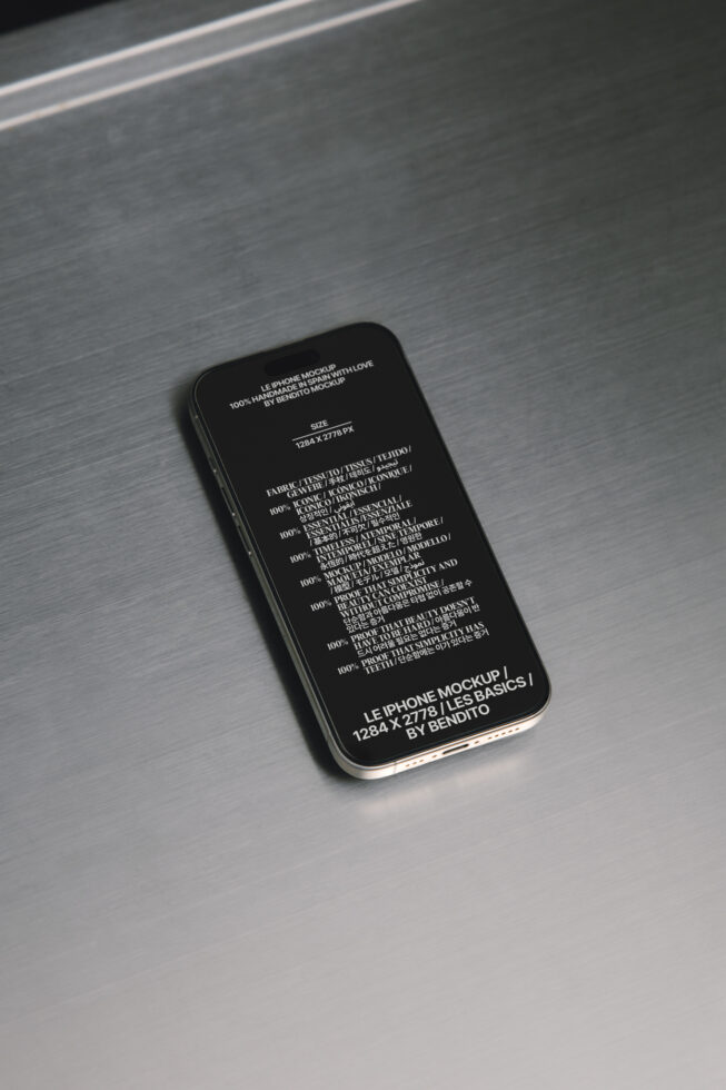iPhone mockup with black screen showing multilingual text on brushed metal surface