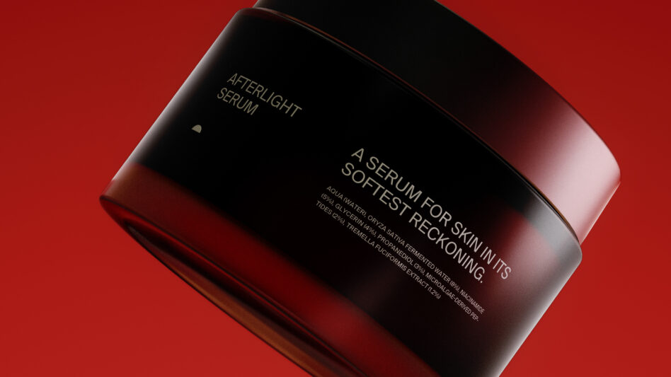 Dark glass jar with rose gold lid showing skincare serum label against red backdrop
