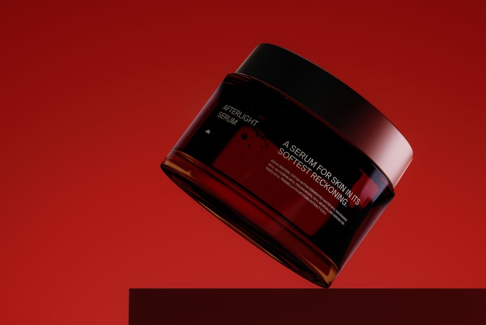 Angled view of burgundy serum bottle with metallic cap on red surface