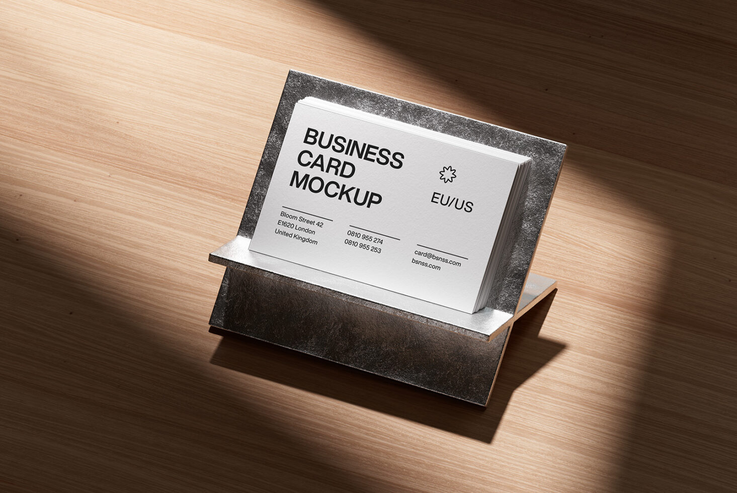 Stack of white business cards in a charcoal metal holder on wood