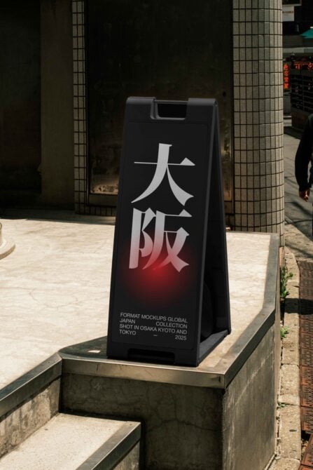 Large black A-frame sign with white Japanese characters glowing red