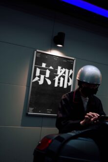 Dark poster mockup with white Japanese kanji mounted on textured wall under blue light strip