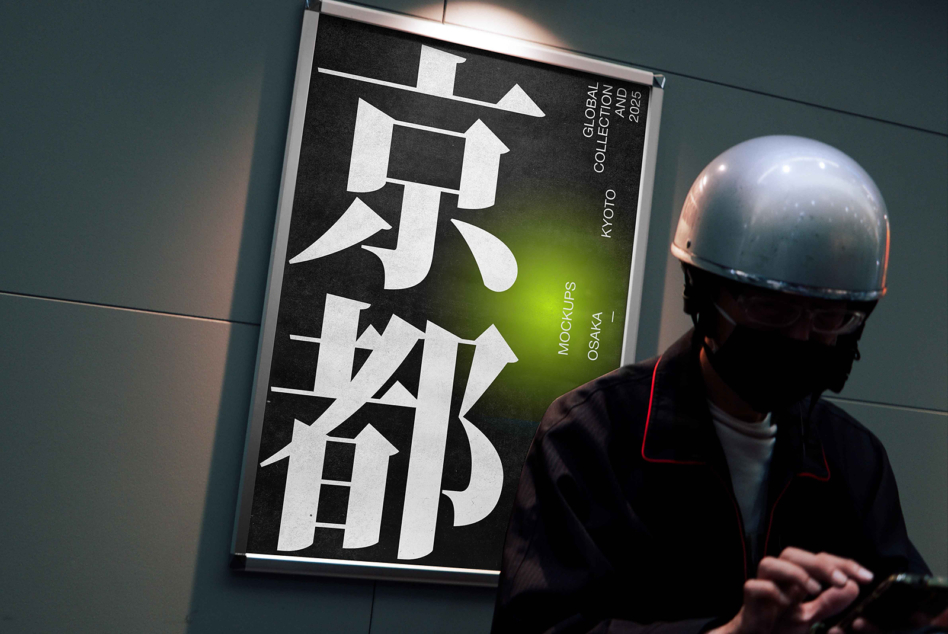 Person in helmet examining framed poster featuring large kanji typography, lime green gradient