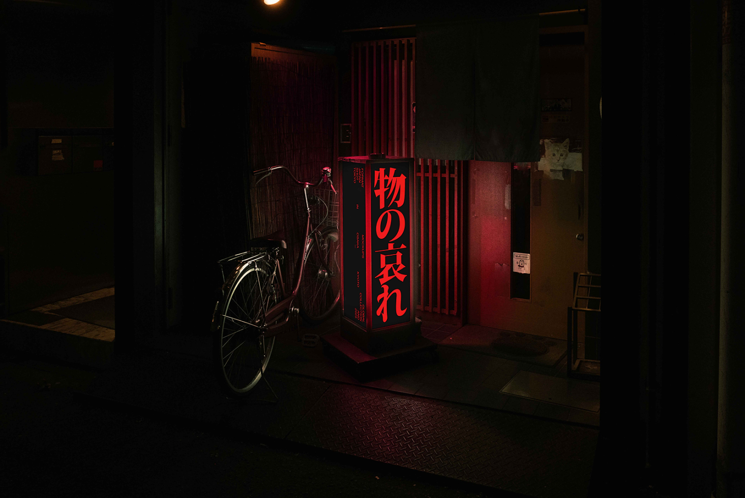 Red neon lit cube sign displaying Japanese characters in moody underground passage setting