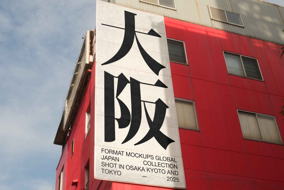 Architectural mockup of cream poster with black Japanese letterforms mounted on red building facade