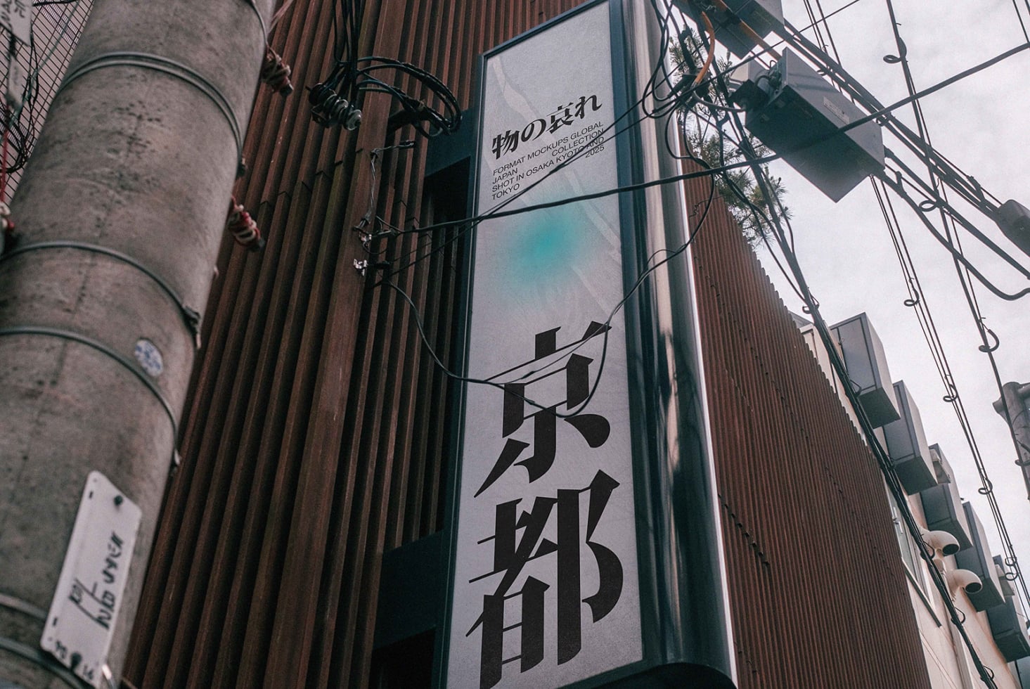 Upward angle of concrete pole, tangled wires, Japanese storefront with white mockup area