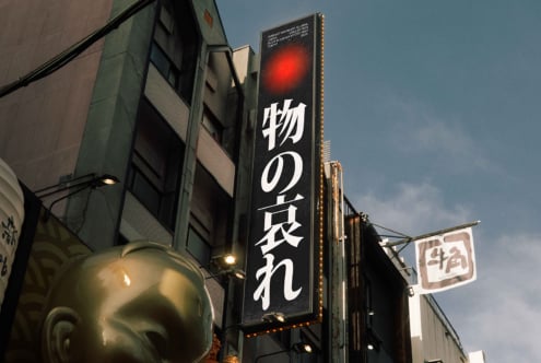 Street-level sign with red glow, white Japanese characters on dark background
