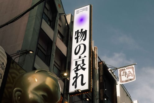 Vertical sign with purple bloom effect, white Japanese text on bright display