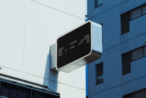 Dark street sign mockup on blue tiled building in urban setting