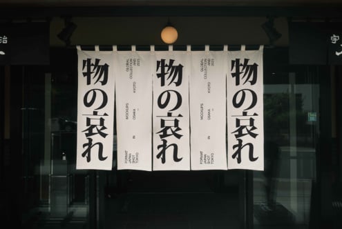 Cream colored banners with black Japanese characters on commercial building