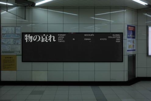 Large black billboard installation in modern subway station with white Japanese lettering on glass tile wall
