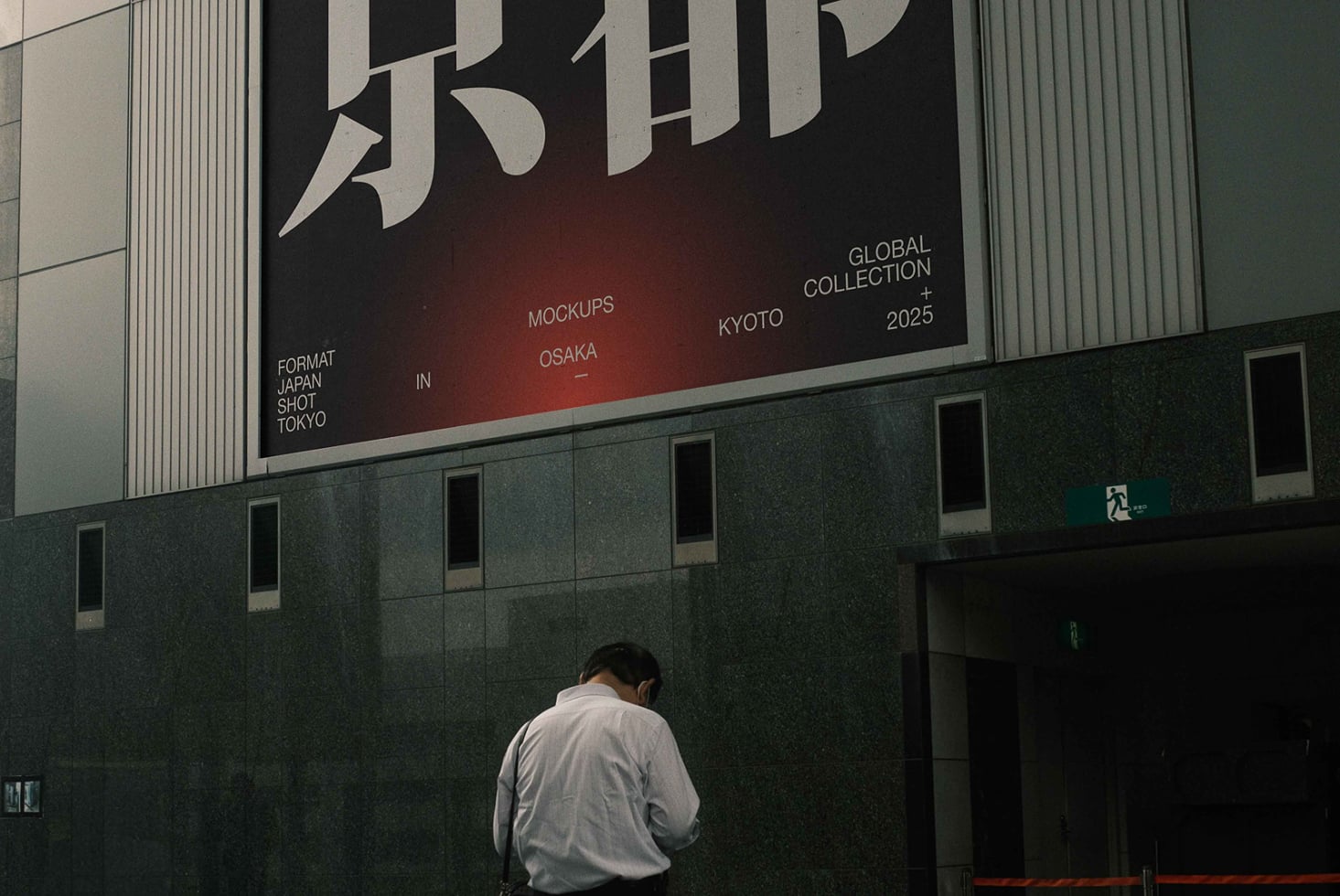 Large building banner with bold Japanese characters, person standing below against green facade